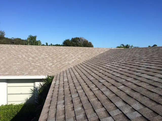 Close view of an asphalt shingle roof ridge under a clear Florida sky