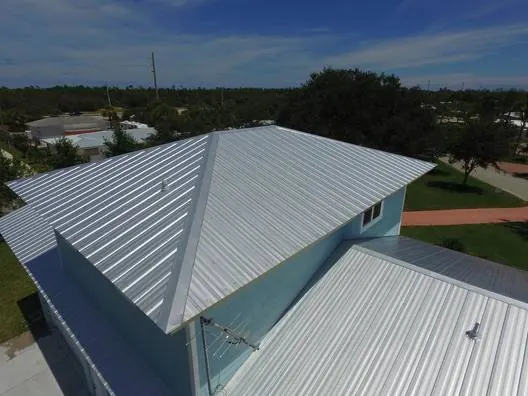 Aerial view of a new silver metal roof on a light-blue two-storey home